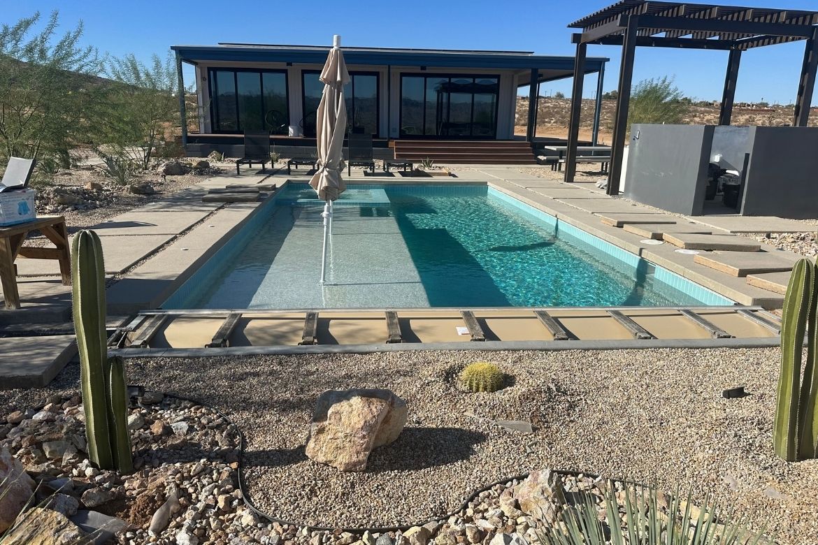 Completed backyard pool with desert landscaping at a modern Joshua Tree home