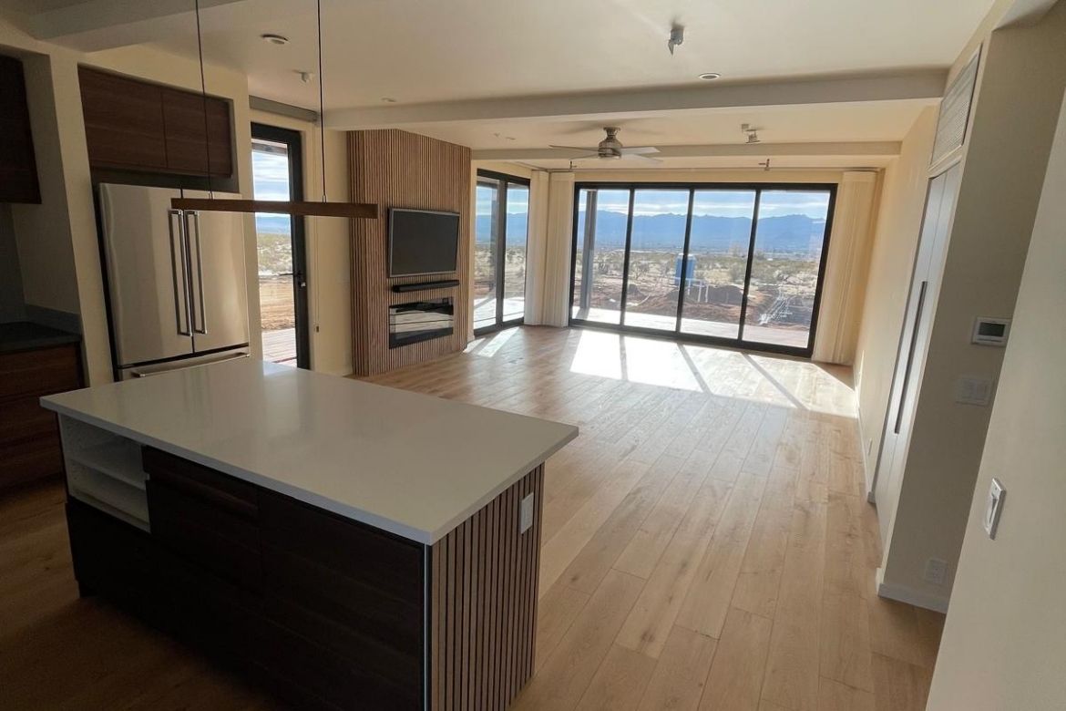 Open-concept living and kitchen space with desert views in a modern Joshua Tree home