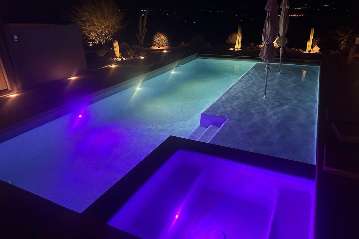 Modern concrete pool and spa with LED lighting at a Joshua Tree desert residence at night