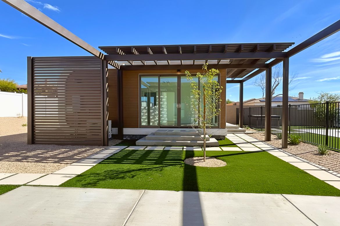 Modern ADU exterior with custom pergola, sliding glass doors, and landscaped yard in Southern California