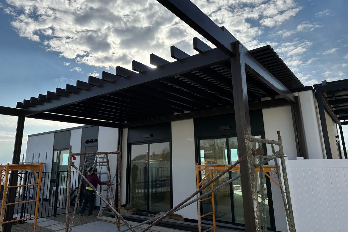 Modern ADU exterior with pergola framing under construction and contemporary architectural finishes