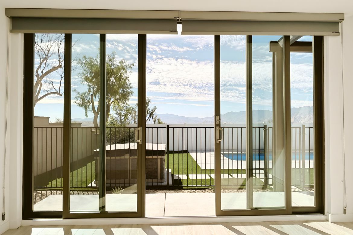 Large sliding glass doors opening to backyard pool and outdoor living area with mountain views